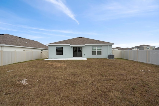 rear view of property with a lawn, cooling unit, and a patio