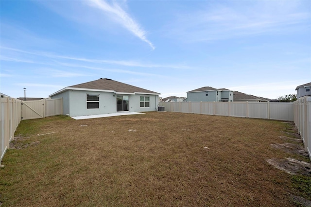 rear view of house featuring a yard and a patio