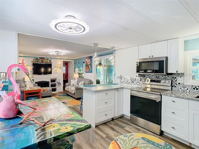 kitchen featuring decorative backsplash, white cabinetry, light hardwood / wood-style flooring, and stainless steel appliances