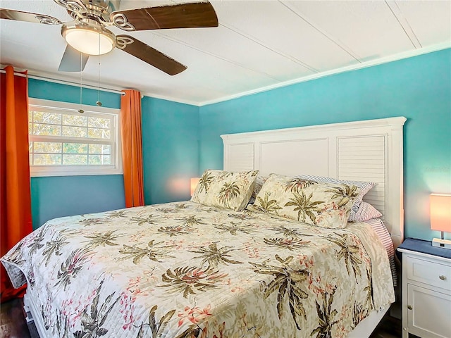 bedroom with dark hardwood / wood-style flooring, ceiling fan, and crown molding