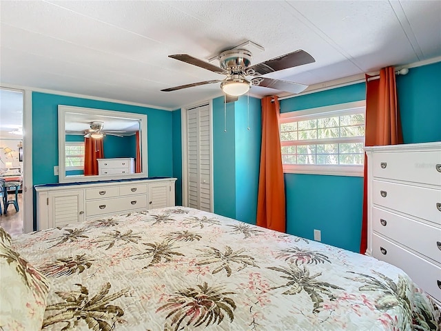 bedroom featuring ceiling fan, a closet, and crown molding