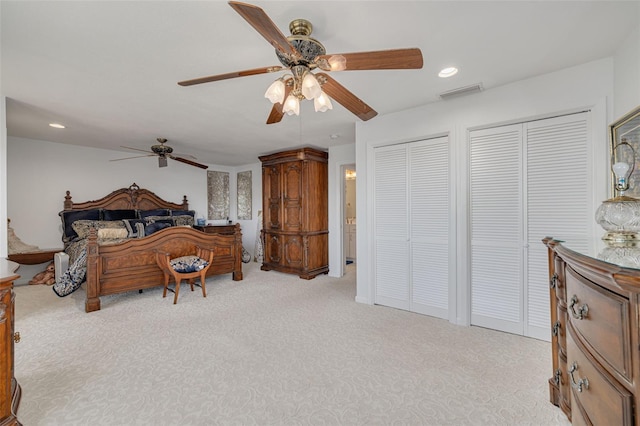 bedroom with visible vents, a ceiling fan, light colored carpet, multiple closets, and recessed lighting