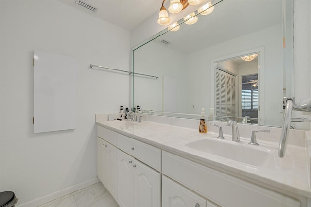 bathroom featuring double vanity, baseboards, visible vents, marble finish floor, and a sink