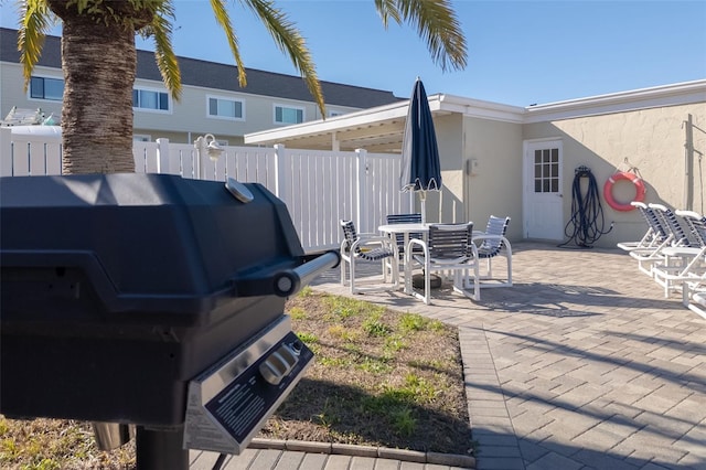 exterior space with outdoor dining space, grilling area, and fence