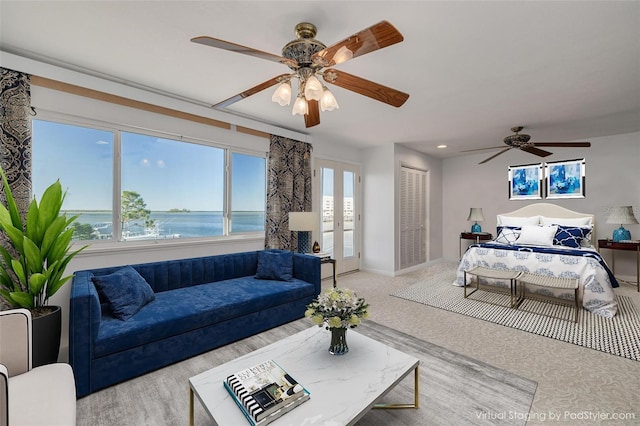 bedroom with ceiling fan, light carpet, a water view, baseboards, and french doors