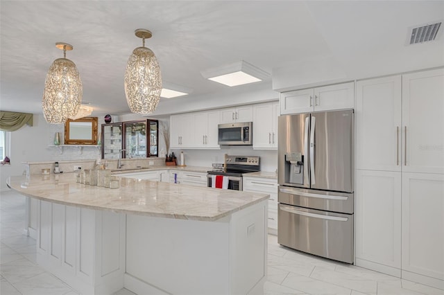 kitchen featuring visible vents, appliances with stainless steel finishes, white cabinets, light stone countertops, and a peninsula