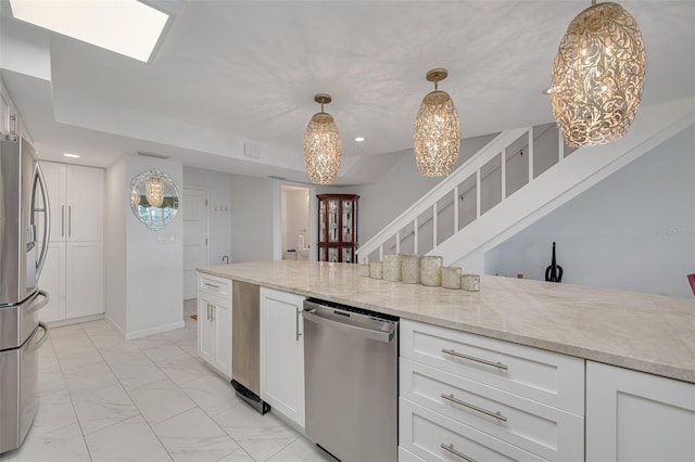 kitchen with stainless steel appliances, white cabinetry, marble finish floor, hanging light fixtures, and light stone countertops