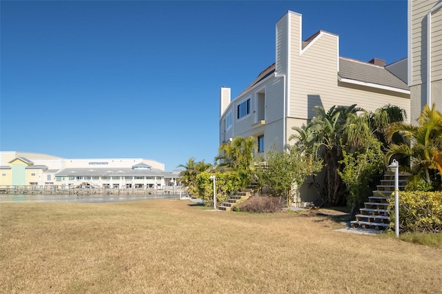 view of yard with a water view and stairway