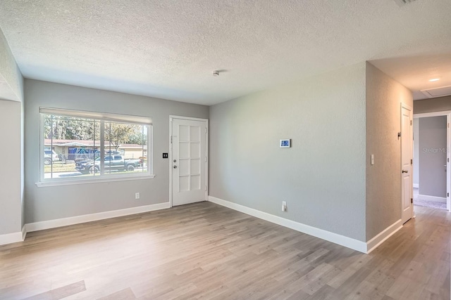 interior space with a textured ceiling and light hardwood / wood-style flooring