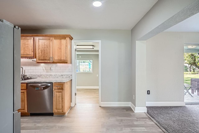 kitchen featuring appliances with stainless steel finishes, backsplash, and light hardwood / wood-style flooring