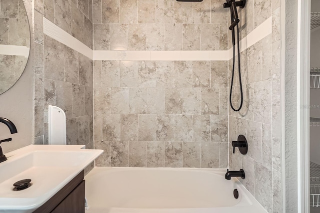 bathroom featuring vanity and tiled shower / bath