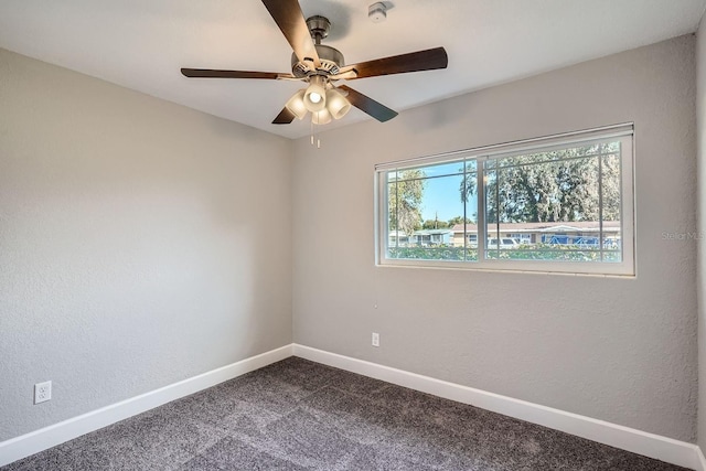 spare room featuring carpet flooring, ceiling fan, and a wealth of natural light