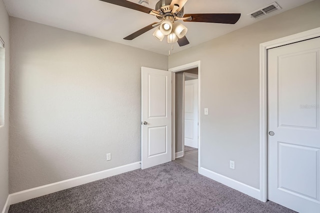 unfurnished bedroom with carpet flooring, ceiling fan, and a closet