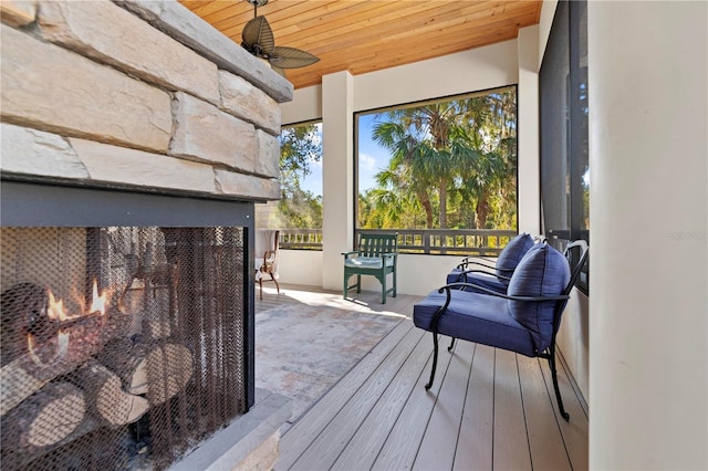 exterior space with ceiling fan, a fireplace, and wood ceiling