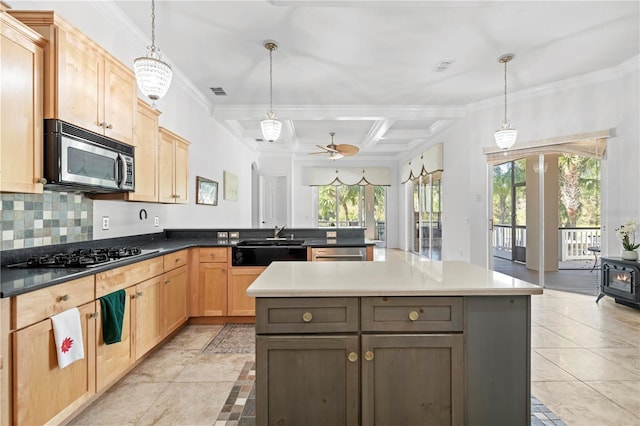 kitchen with a healthy amount of sunlight, a center island, stainless steel appliances, and decorative light fixtures