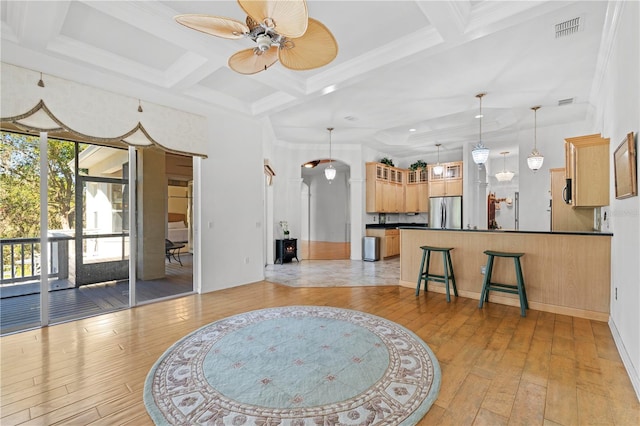 living room featuring light wood-type flooring, coffered ceiling, ceiling fan, crown molding, and beamed ceiling