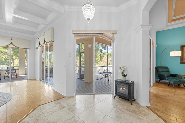 entrance foyer with coffered ceiling, crown molding, beam ceiling, an inviting chandelier, and light hardwood / wood-style floors