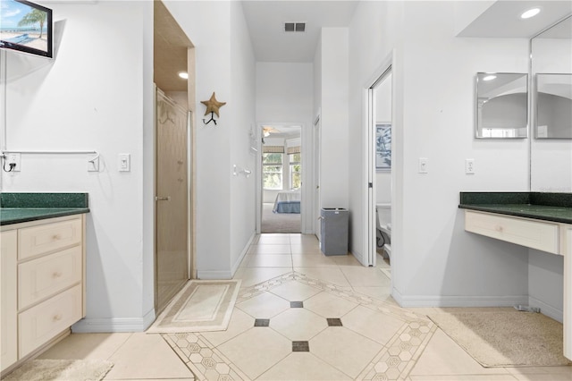 bathroom featuring toilet, vanity, tile patterned floors, and walk in shower