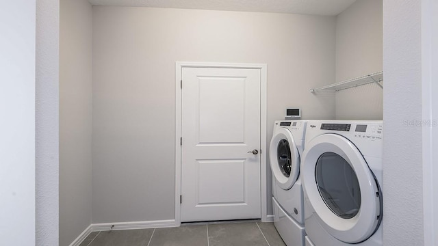 clothes washing area with light tile patterned floors and washing machine and dryer