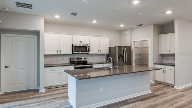 kitchen featuring appliances with stainless steel finishes, sink, a center island with sink, and white cabinets