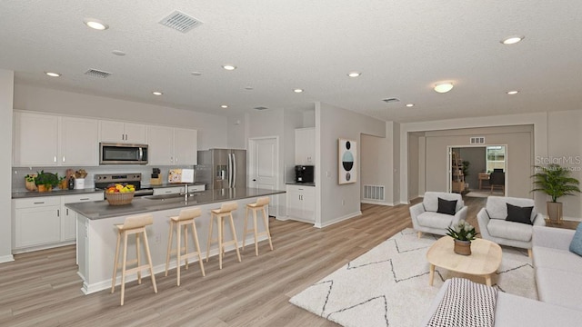 interior space featuring sink, light hardwood / wood-style flooring, and a textured ceiling