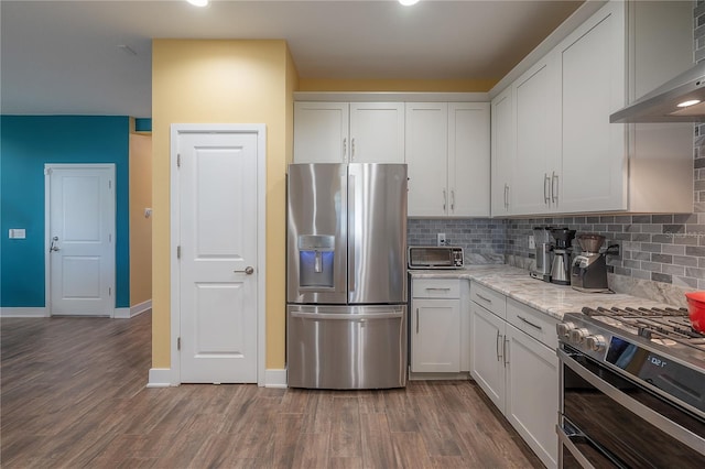 kitchen featuring wall chimney exhaust hood, dark hardwood / wood-style floors, white cabinetry, and appliances with stainless steel finishes