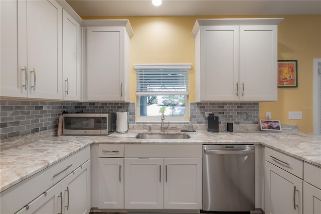 kitchen with dishwasher, decorative backsplash, white cabinetry, and sink