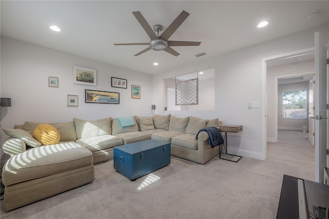 carpeted living room with ceiling fan