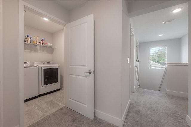 clothes washing area with light colored carpet and separate washer and dryer