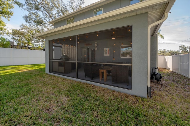 rear view of house with a yard and a sunroom