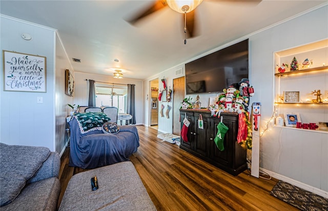 living room with dark hardwood / wood-style floors, ceiling fan, and crown molding