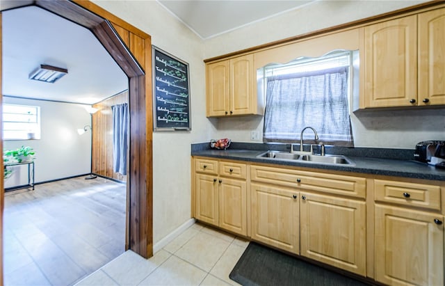 kitchen with light brown cabinetry, sink, and light tile patterned floors