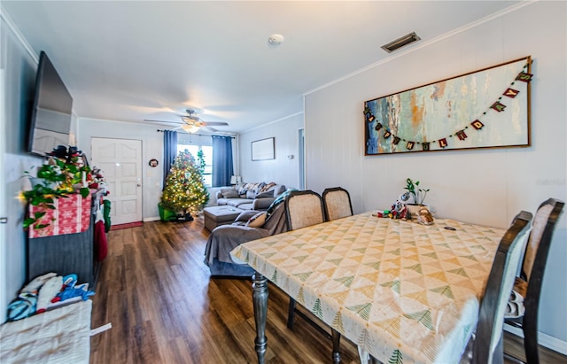 dining room with dark wood-type flooring, ceiling fan, and ornamental molding