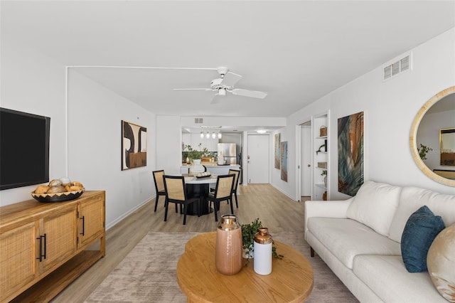 living room featuring ceiling fan and light hardwood / wood-style flooring