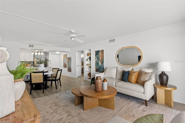 living room with ceiling fan and light wood-type flooring