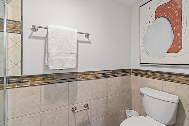 bathroom featuring tile walls and toilet