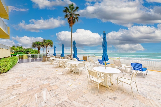 view of patio / terrace featuring a beach view and a water view