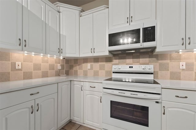 kitchen featuring backsplash, white cabinets, and white appliances