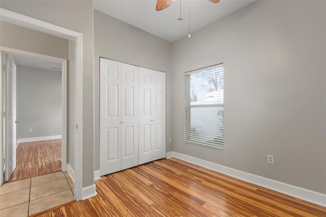 unfurnished bedroom featuring a closet, light hardwood / wood-style flooring, and ceiling fan