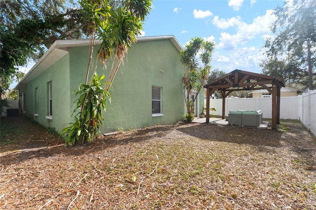 view of side of home with outdoor lounge area, a gazebo, and central AC unit