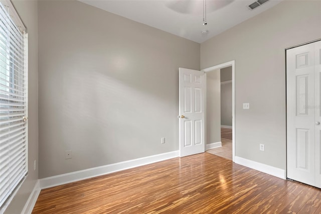 unfurnished bedroom featuring hardwood / wood-style floors and ceiling fan