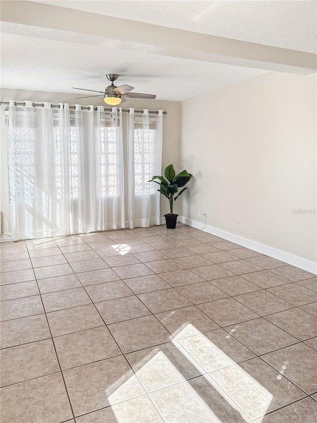 tiled spare room with ceiling fan