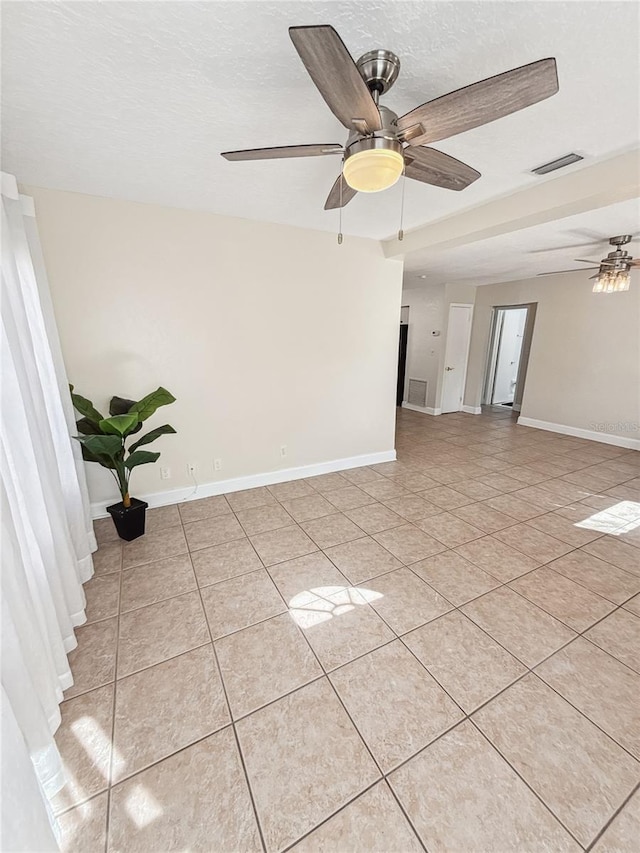 tiled spare room featuring ceiling fan