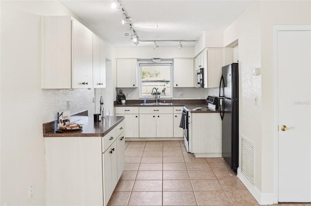 kitchen featuring sink, light tile patterned floors, white cabinetry, stainless steel appliances, and a textured ceiling