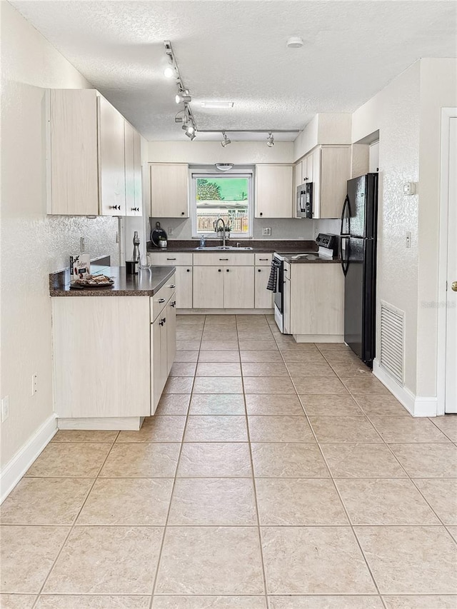 kitchen with sink, range with electric cooktop, a textured ceiling, and black fridge