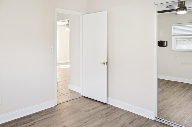 unfurnished bedroom with ceiling fan and light wood-type flooring