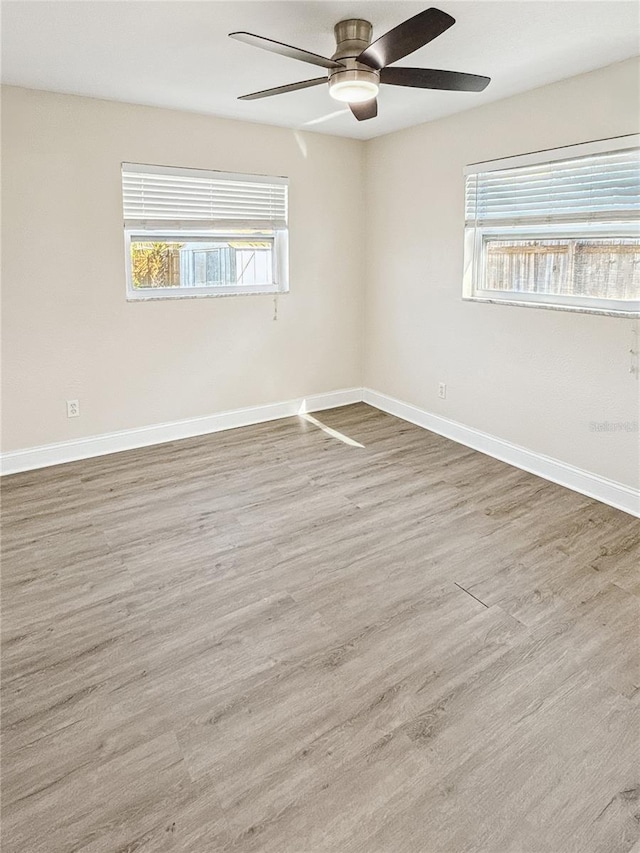 empty room featuring hardwood / wood-style floors, a wealth of natural light, and ceiling fan