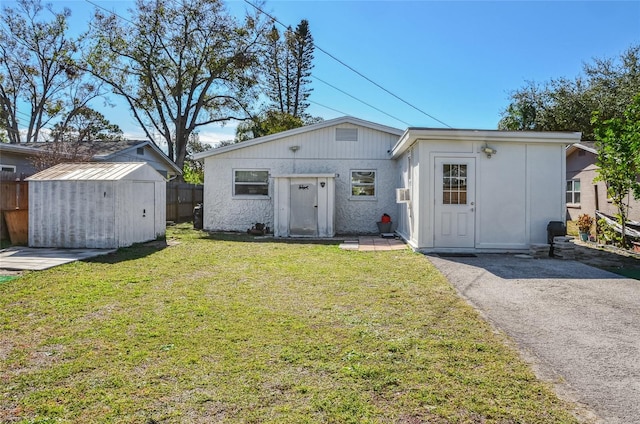 ranch-style house featuring a front yard and a storage unit