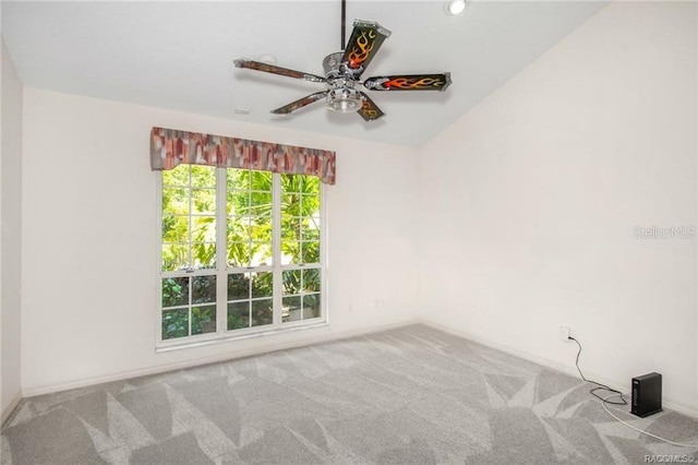 carpeted spare room with ceiling fan and lofted ceiling