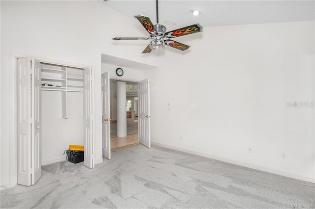 unfurnished bedroom featuring ceiling fan, lofted ceiling, and light carpet